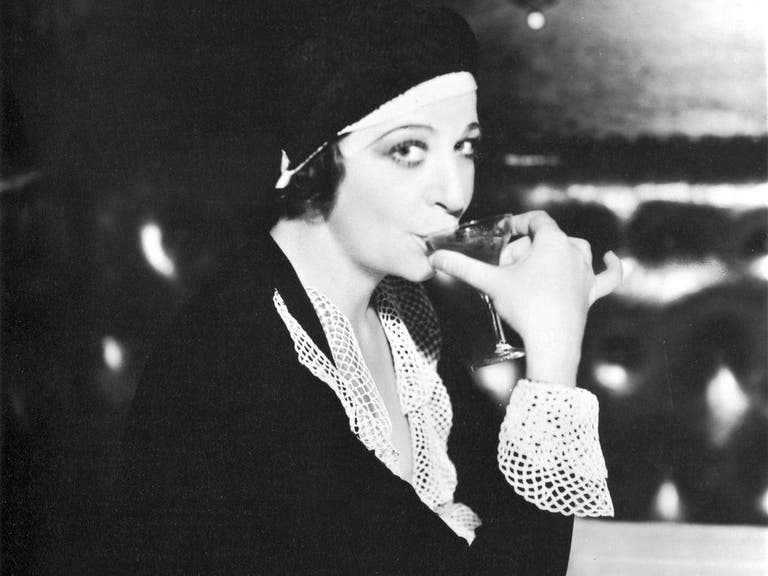 Comedienne Fanny Brice sipping a cocktail in Hollywoods Classic era