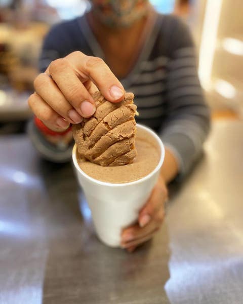 Mini-concha dipped in champurrado at El Aguila Bakery