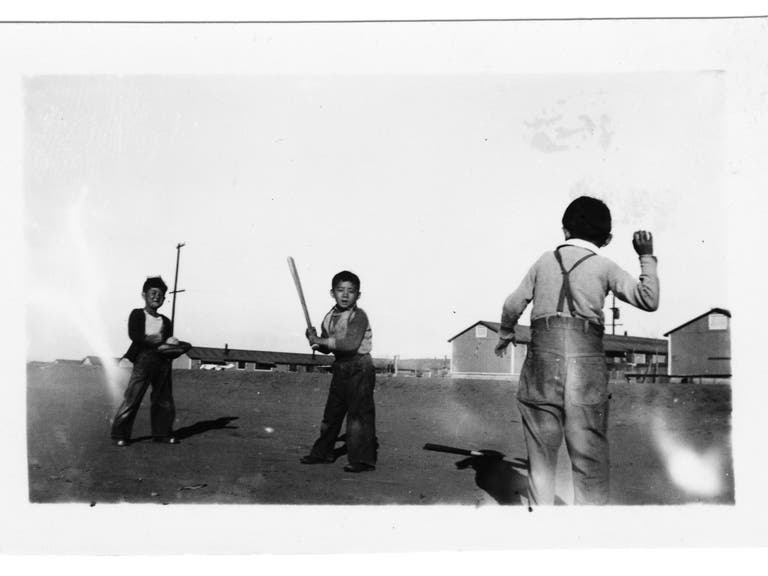Three young boys play baseball outside the barracks, from "Don't Fence Me In" at JANM